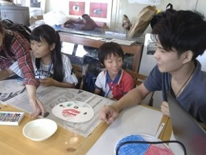 団扇に絵付け作業指導中